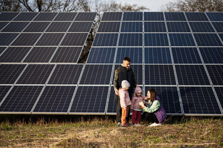 Family with two daughters on the background of solar panels. Eco energy.