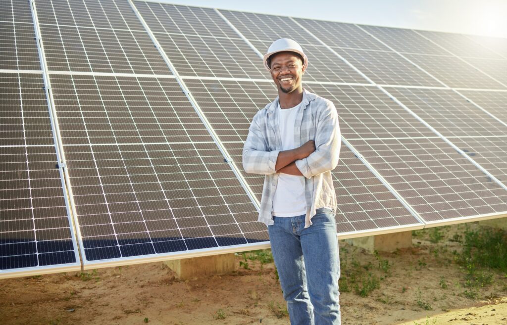 Farming is a calling. Shot of a young man standing in front of solar panel on a farm.